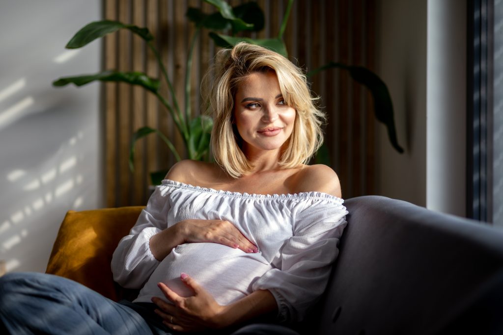 Motherhood expectation at home pretty pregnant woman resting on sofa