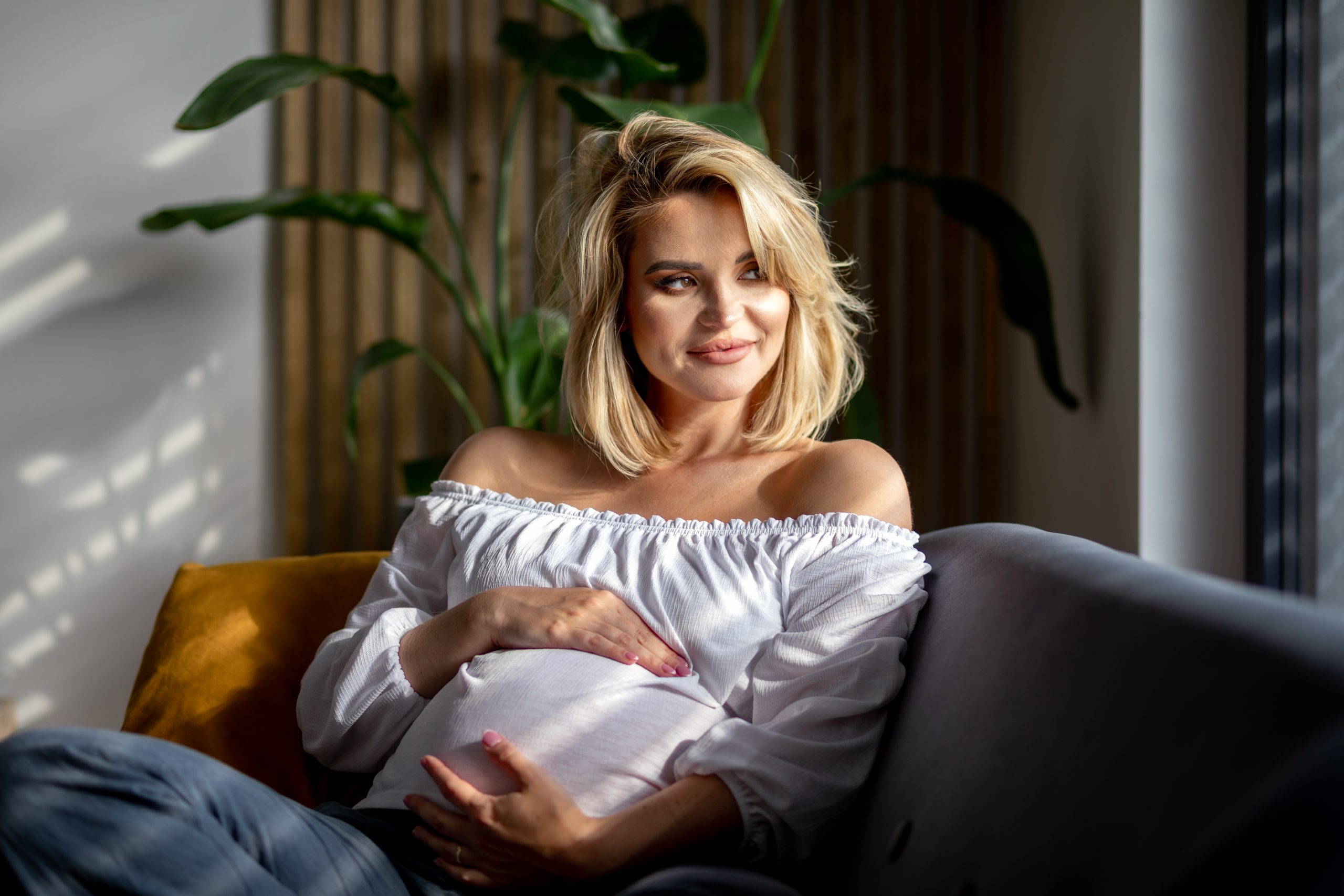 Motherhood expectation at home pretty pregnant woman resting on sofa